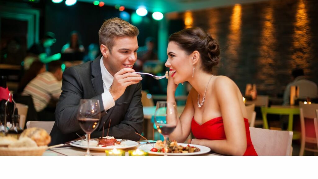 A man and woman savoring a delicious meal at a restaurant, surrounded by elegant decor and ambiance