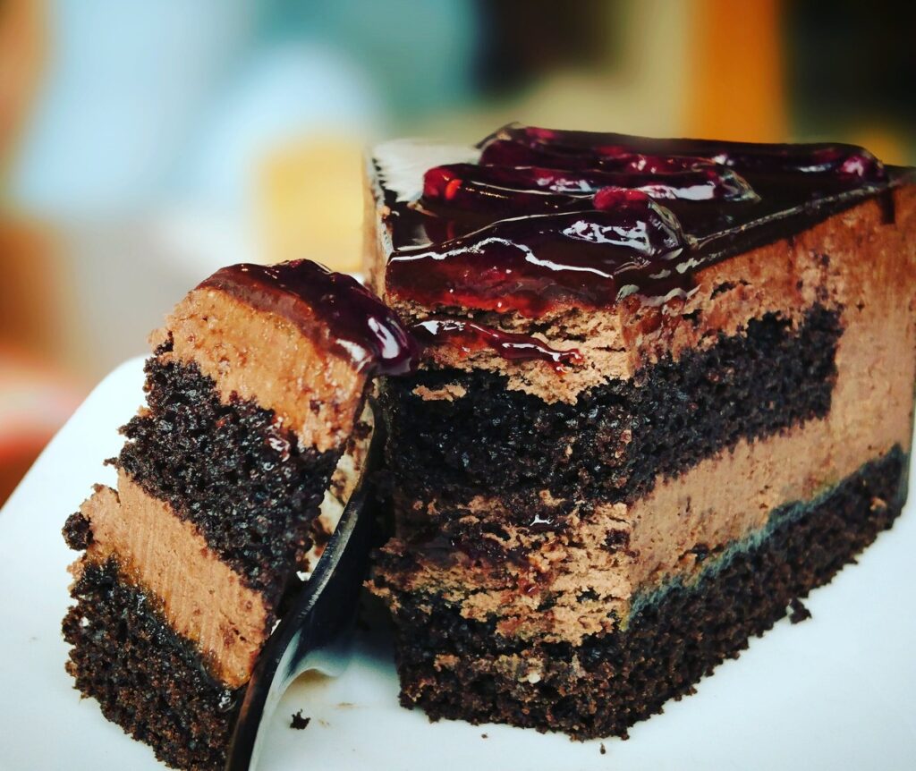 A delectable slice of cake resting on a pristine plate, enticingly tempting with its irresistible sweetness