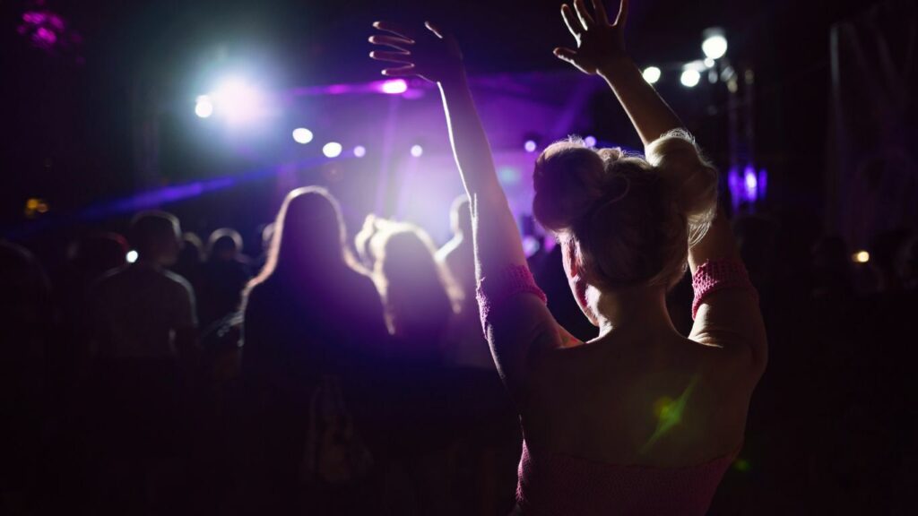 a person with their arms up in the air at a concert